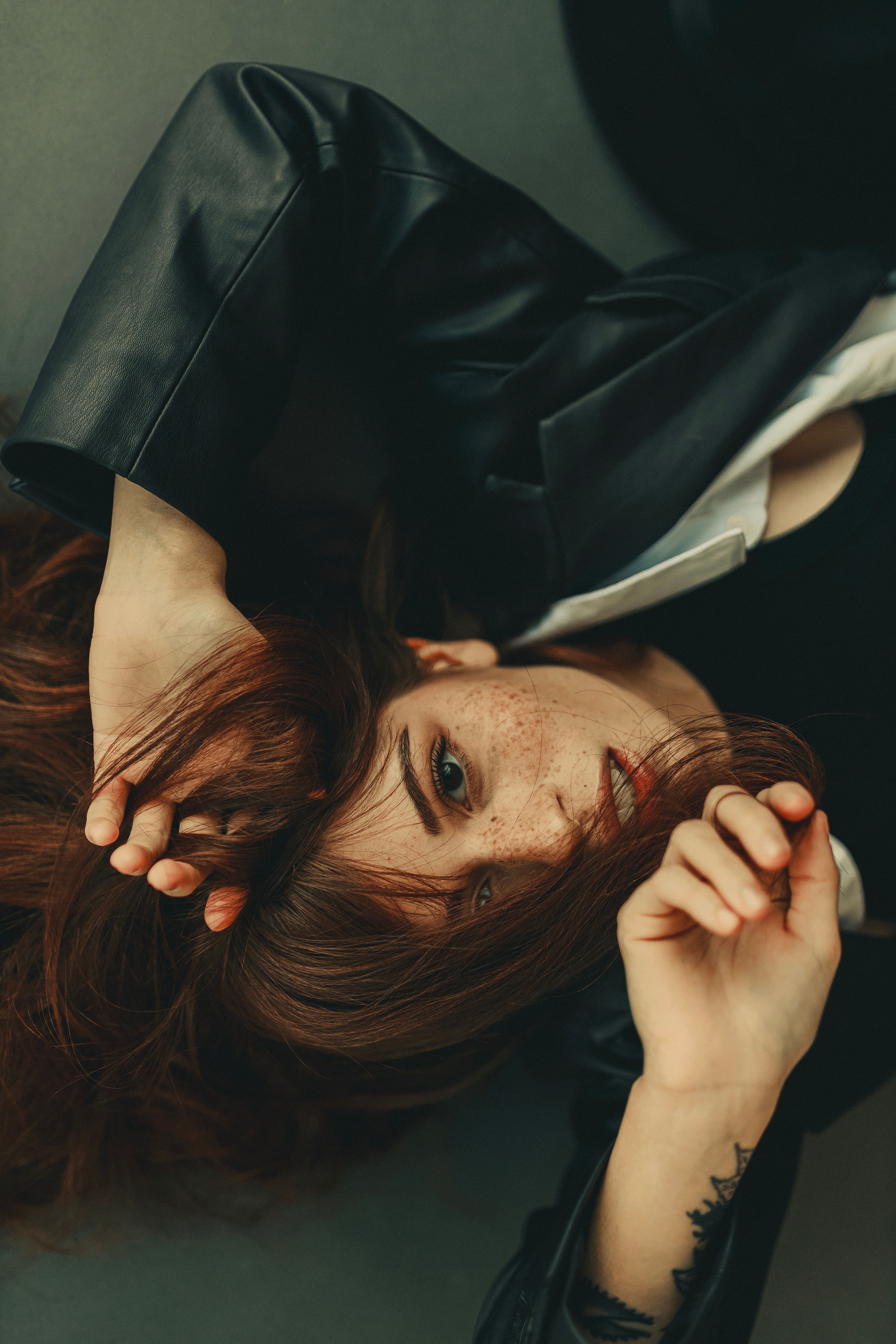 Young Woman in a Leather Jacket Lying on the Floor · Free Stock Photo