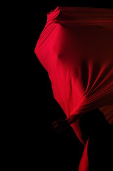 Abstract silhouette art with red fabric and dramatic lighting, expressing mystery and form.