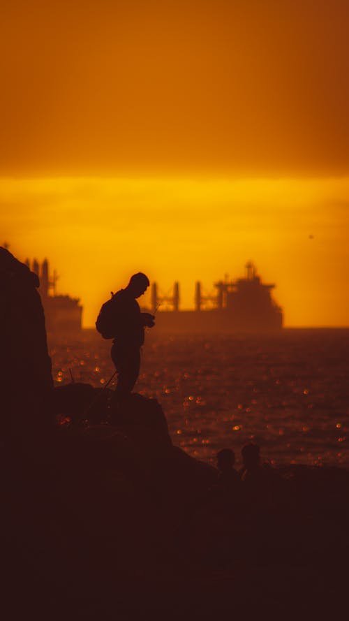 Silhouette of Man by the Sea During Sunset 