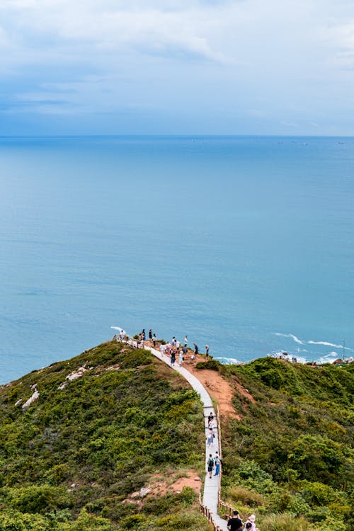 People Hiking on a Footpath at a Seaside Hill Top
