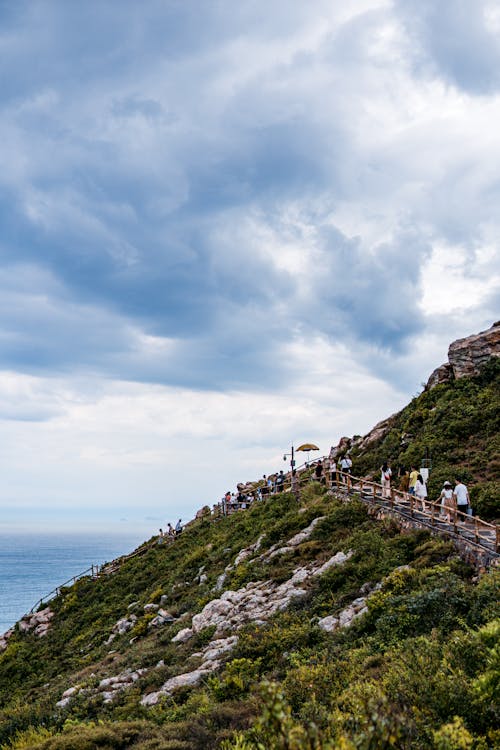 People Climbing Up Stairs on a Seashore Hill