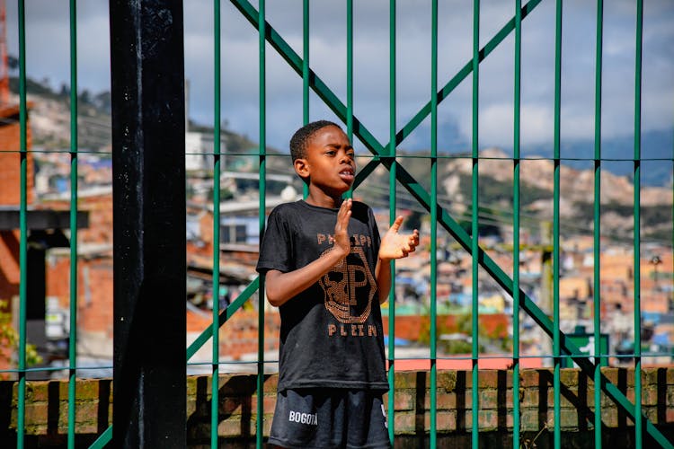 Boy Standing Near Fence