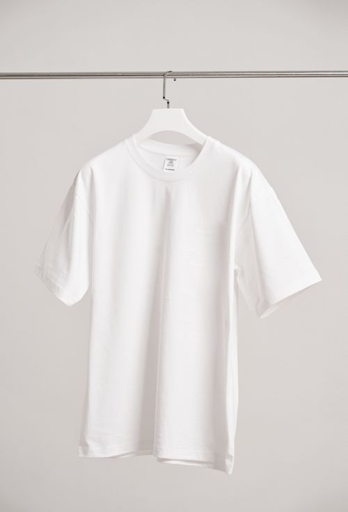 White t-shirt hanging on a rail — photo by dayong tien on Pexels