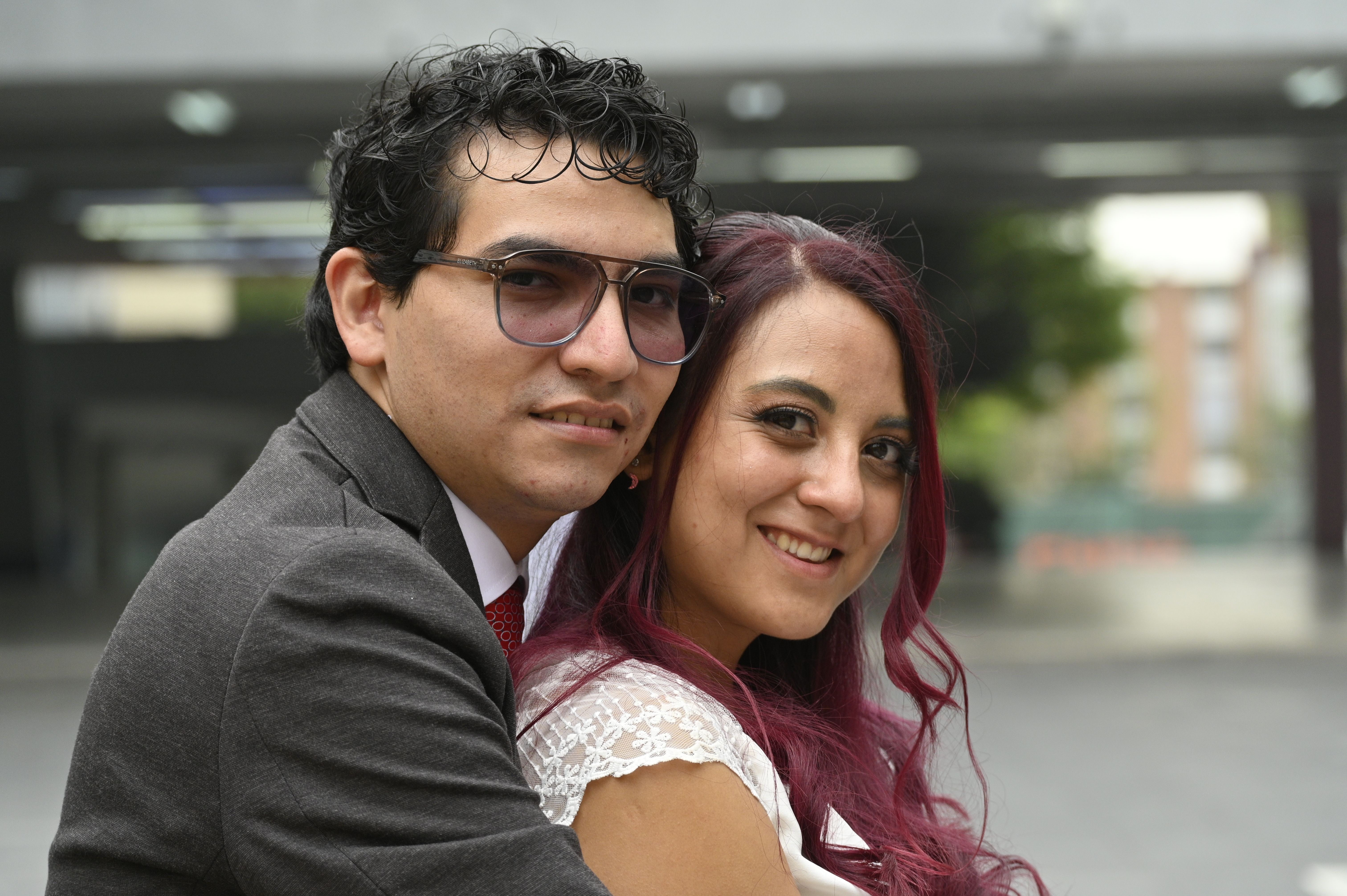 A joyful newlywed couple sharing a tender embrace outdoors on their wedding day.