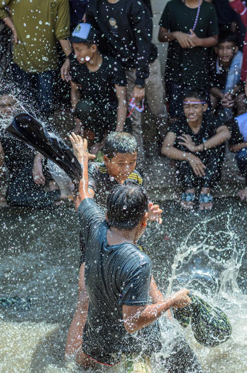 Teenager Boys Splashing in Water