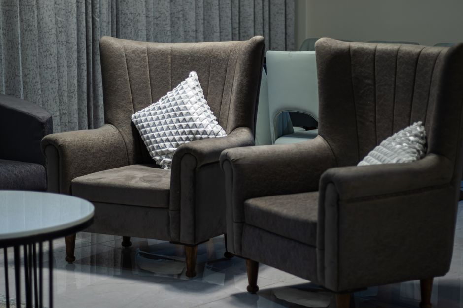 Two brown armchairs with decorative pillows in a cozy stylish interior representing the social setting of hookah etiquette