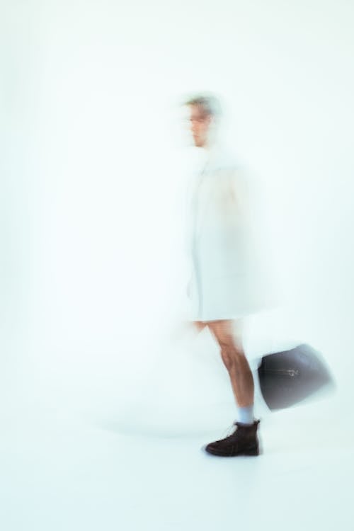 Man Wearing White Coat in Blur