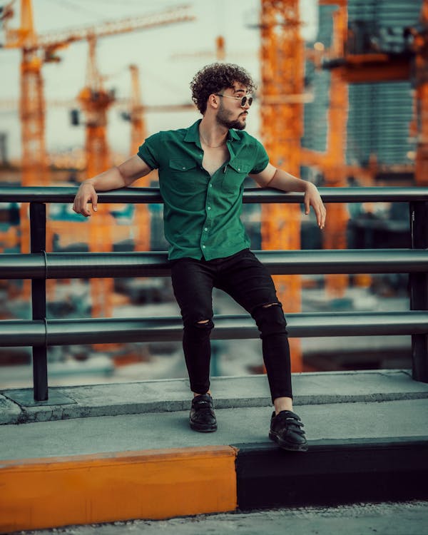 Man Posing in Ripped Jeans and Strap Trainers Free Stock Photo