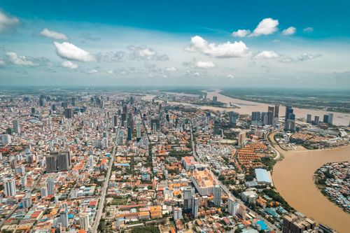 Free Stunning aerial view of Phnom Penh's skyline along the river under a blue sky. Stock Photo