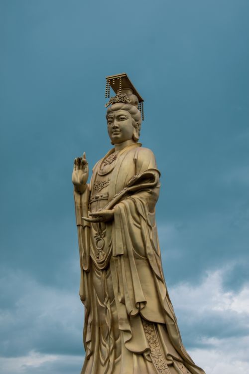 Free A majestic Guanyin statue standing tall against a cloudy sky on Mount Putuo, China. Stock Photo