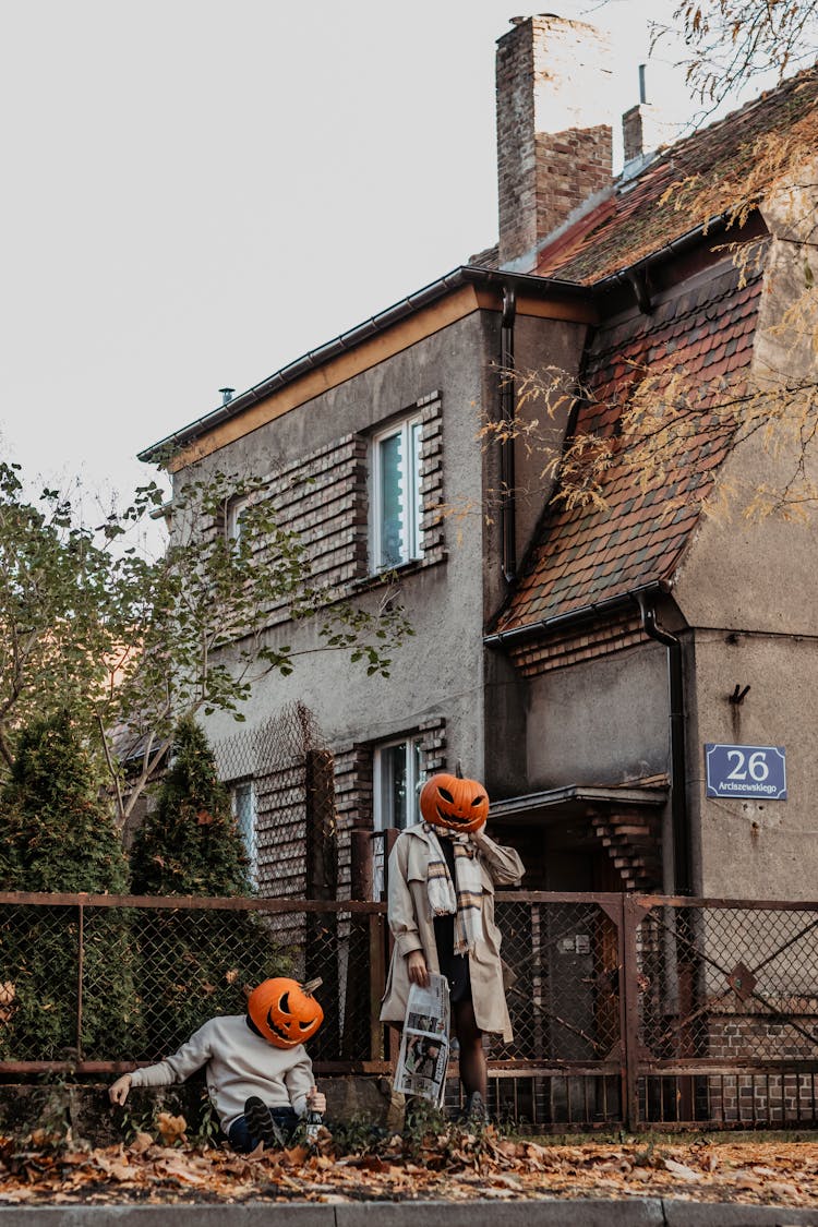 People With Pumpkin Heads Standing Near House