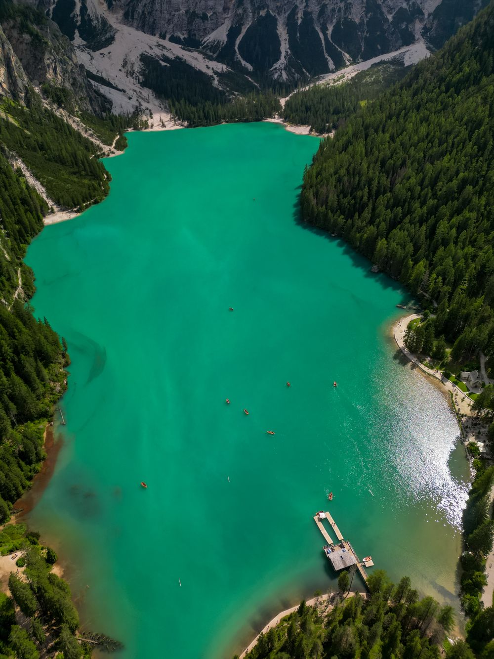 Malul Lacului Braies cu poteca de ocol și pădurea de conifere