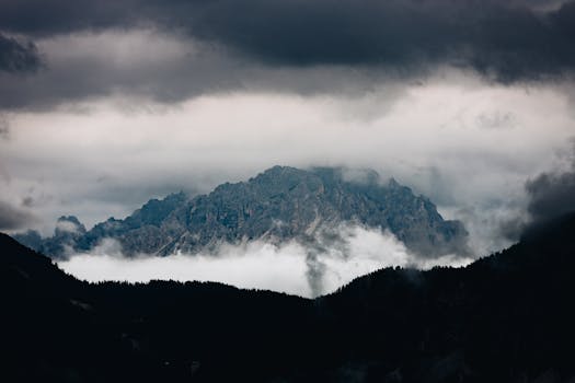 A scenic mountain peak partially obscured by clouds creates a dramatic natural landscape.