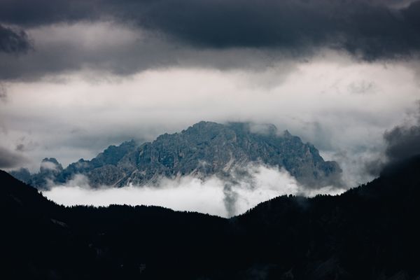 Cloud bank rolling over a dark mountain ridge — photo by urtimud.89 on Pexels