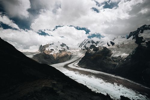 Free Stunning view of snowcapped mountains and glacier under a dramatic sky. Stock Photo