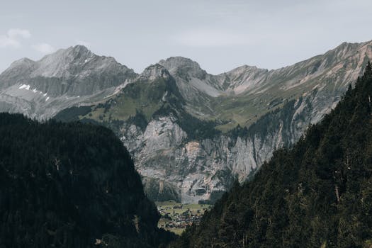 A picturesque mountain village nestled in a lush alpine valley surrounded by rocky peaks.