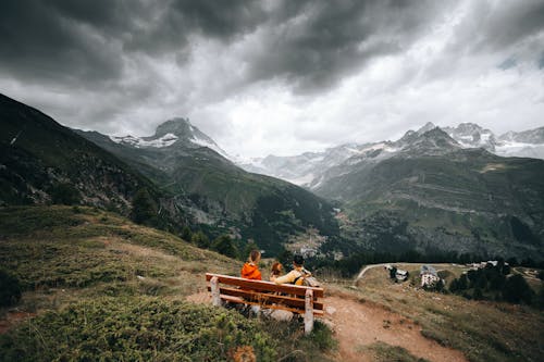 Couple Sitting on Bench in Mountains