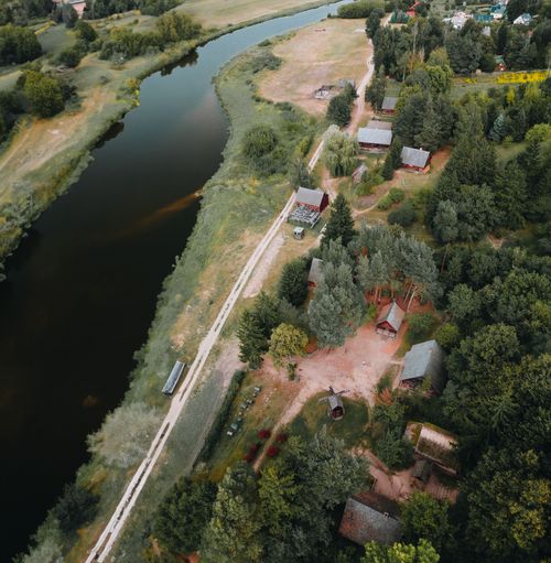 Free Aerial view of a tranquil countryside with houses, trees, and a river, captured in square format. Stock Photo
