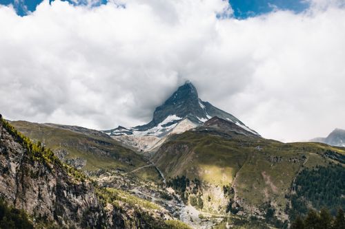 Free Stunning view of the Matterhorn peak shrouded in clouds against a lush green landscape. Stock Photo