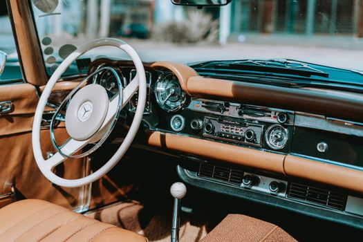Close-up view of a vintage Mercedes car interior showcasing the dashboard and steering wheel.