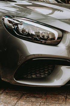 Detailed close-up shot highlighting the sleek design of a silver sports car's headlight.
