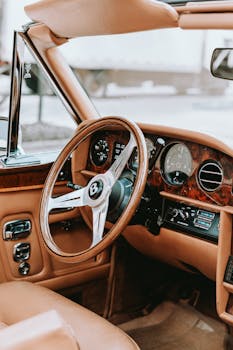 Explore a luxurious vintage car interior with a retro wooden dashboard and leather seats.