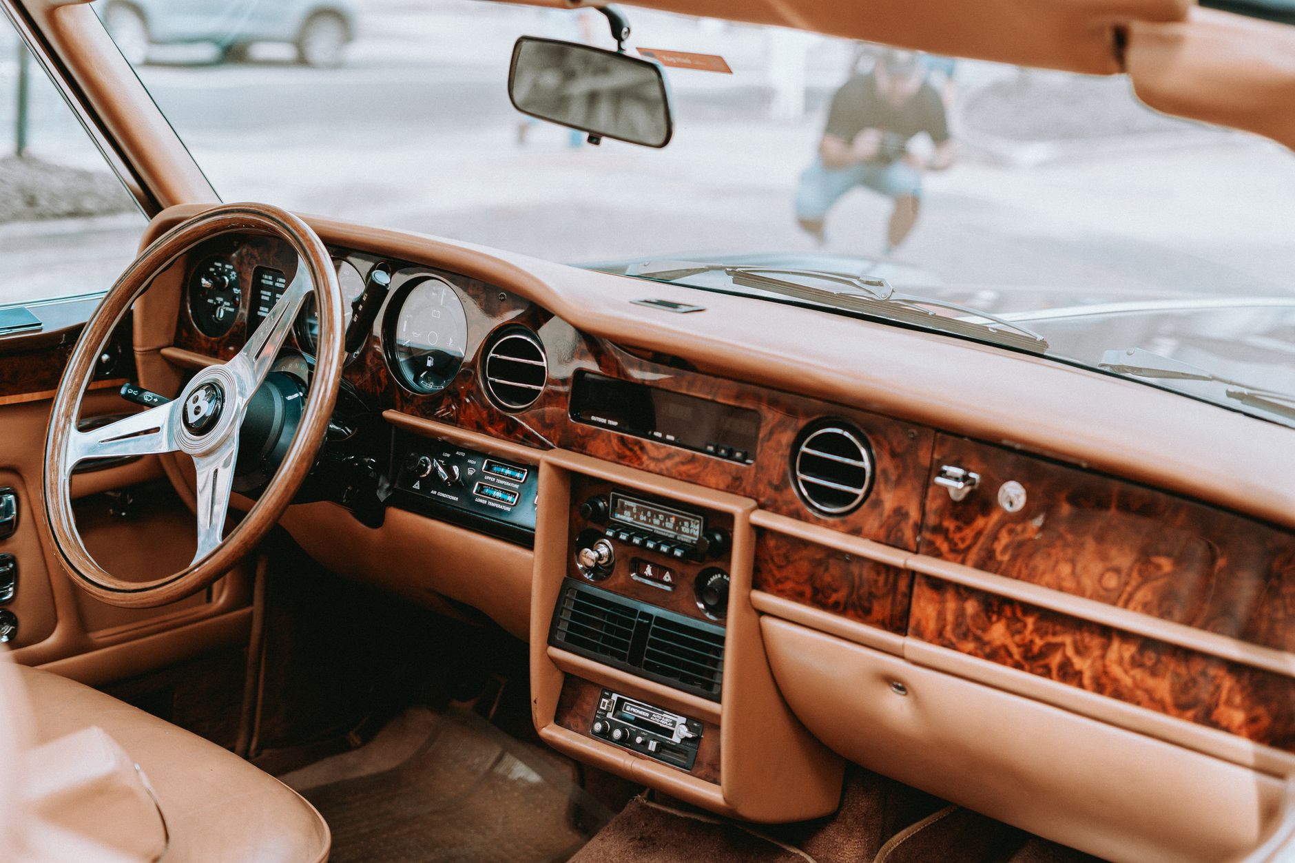 Explore the opulent wooden dashboard and leather seats of a vintage luxury car interior.