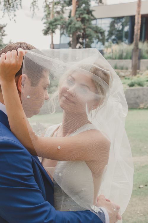 Free A tender moment captured between a bride and groom on their wedding day outdoors. Stock Photo