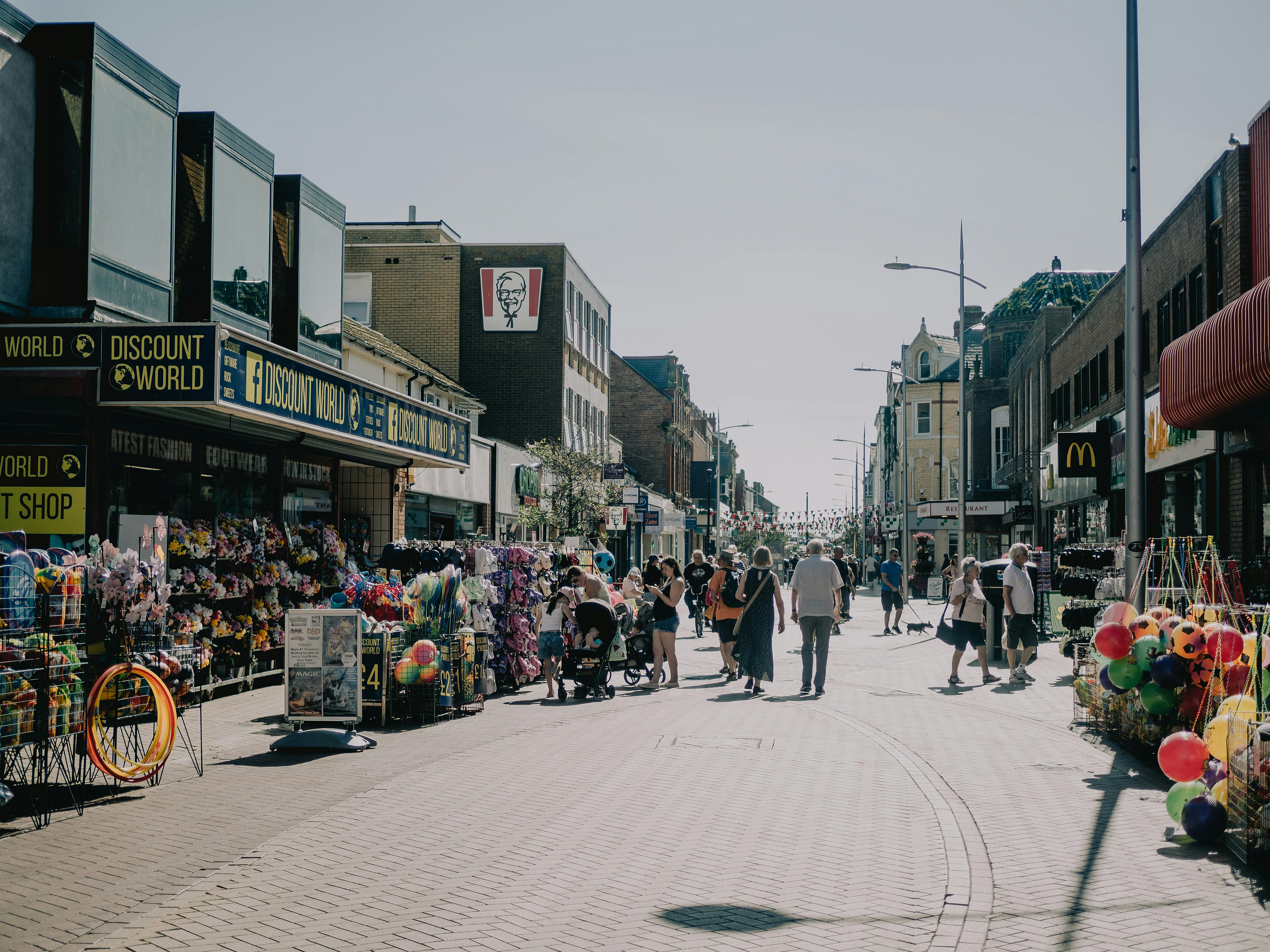 A bustling pedestrian street with shops and people, creating an urban and lively atmosphere.