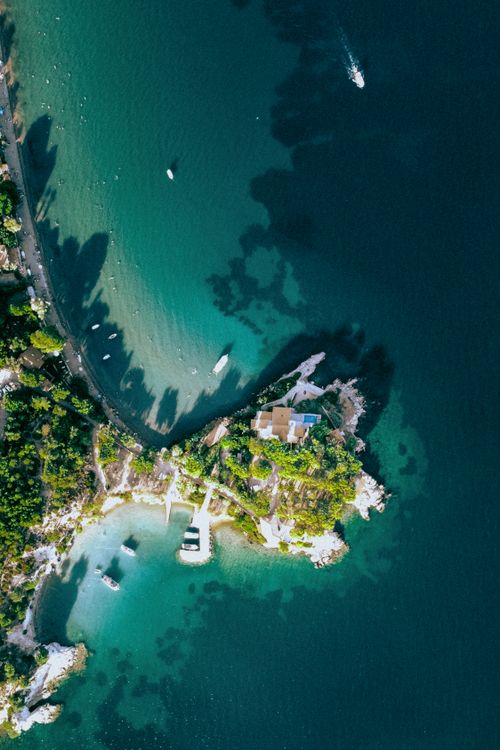 Free Stunning aerial view of a tropical island resort surrounded by turquoise sea and lush greenery. Stock Photo