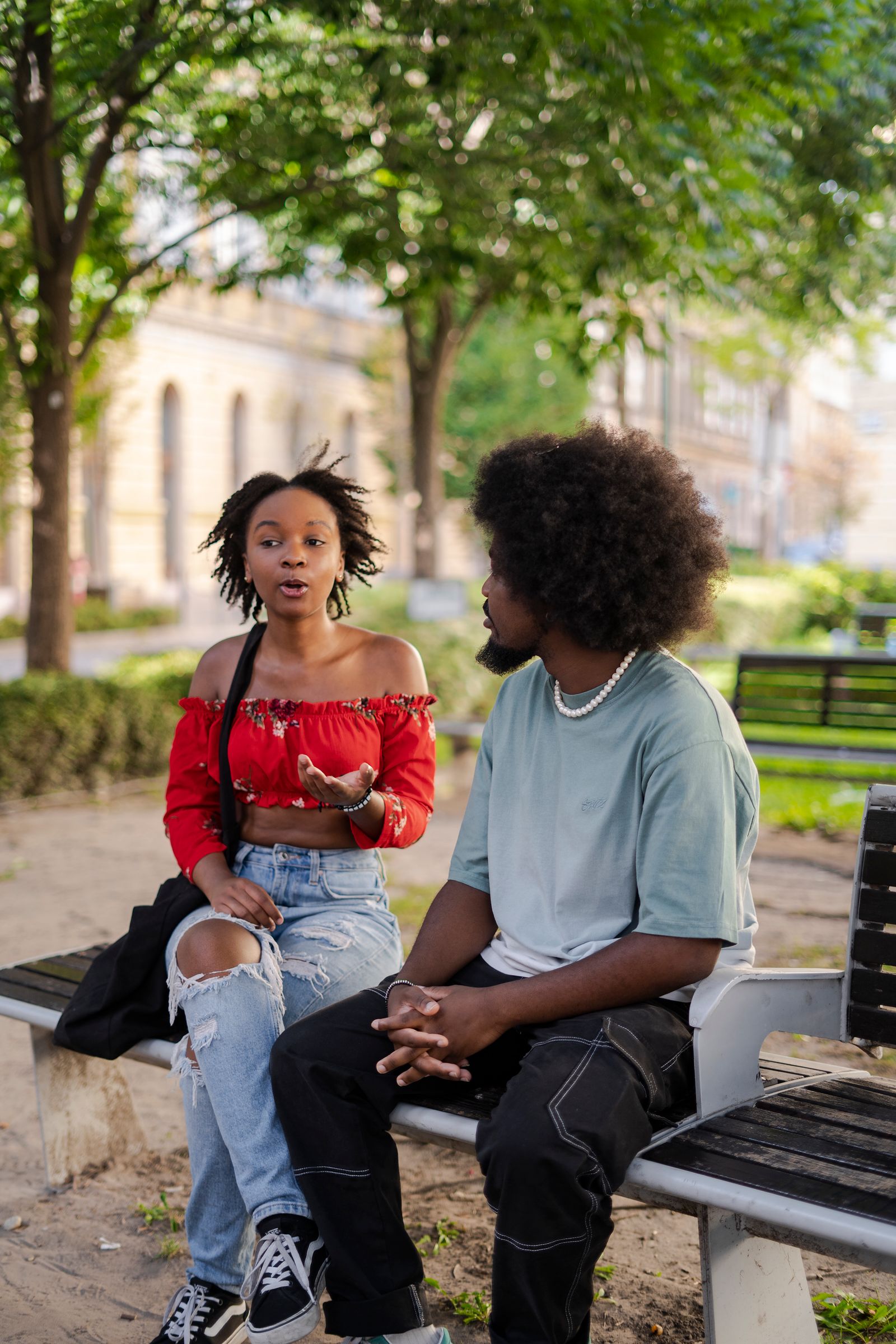 Two people talking together on a park bench