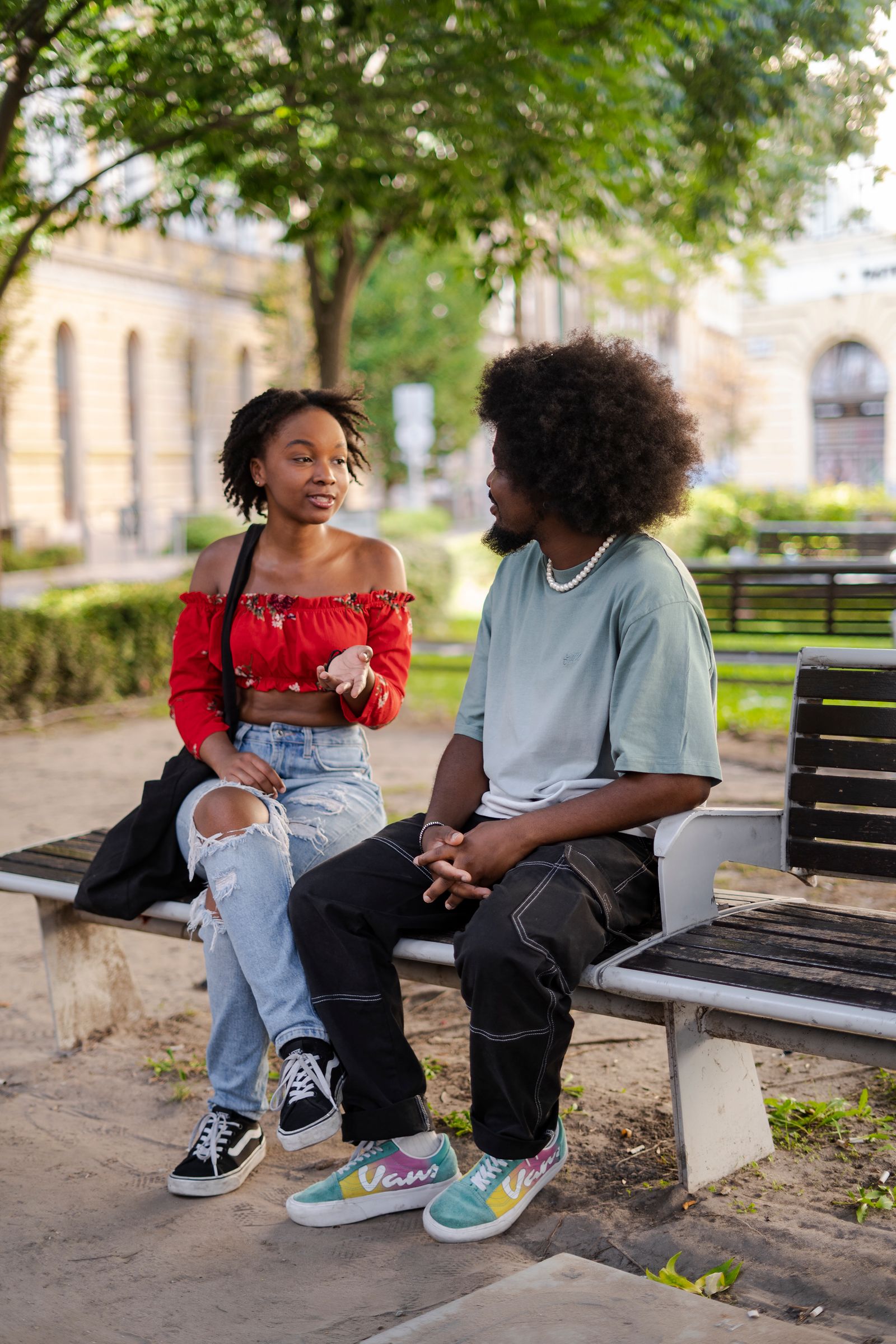 Two people sitting on a park bench in conversation