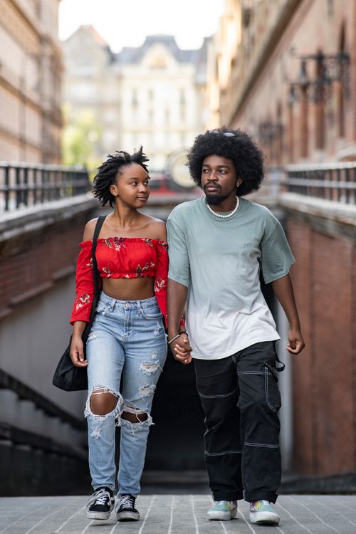 Free A young couple holding hands while walking down a city street in Budapest, Hungary. Stock Photo