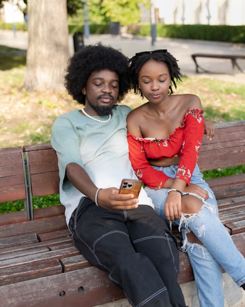 Embracing Couple Sitting on Bench and Taking Selfie with Smartphone