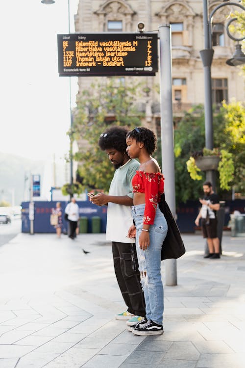 Kostnadsfri bild av busshållplats, kvinna, man
