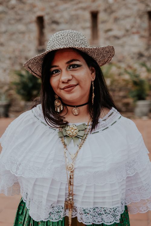 Free Smiling woman in traditional clothing and jewelry, standing outdoors. Stock Photo