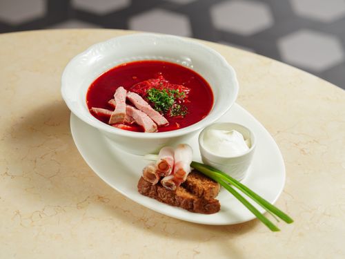 Free Appetizing borscht soup served with sour cream and bread, perfect for a cozy meal. Stock Photo