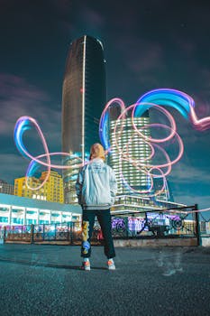 Colorful light trails and modern skyscrapers in Baku's vibrant urban nightscape.