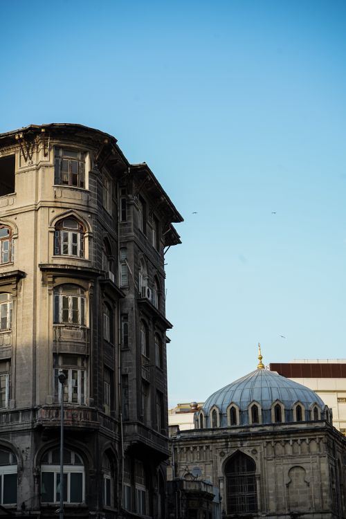 Free Capture of an old building and mosque dome under a clear blue sky in Istanbul. Stock Photo