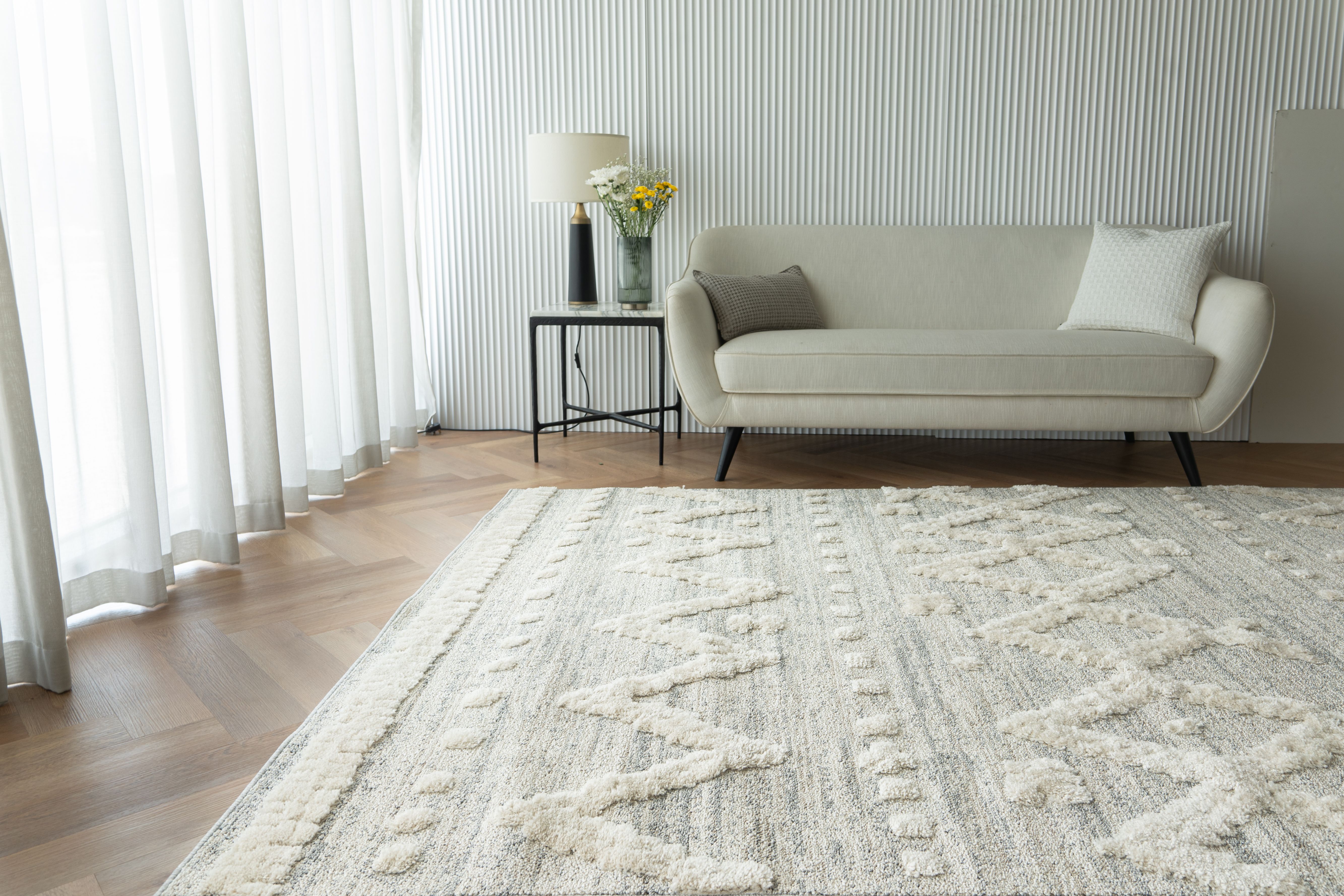 Stylish living room with cozy carpet, sofa, and bright lighting in Dubai.