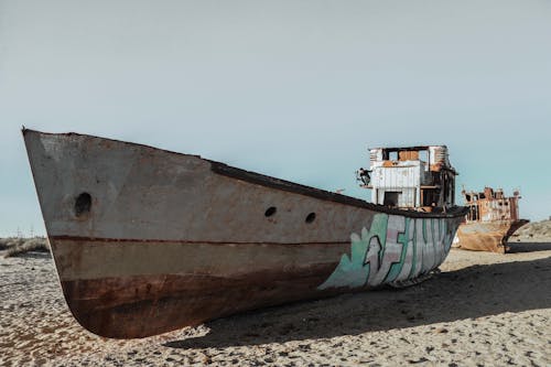 Photo of gray and teal boat on seashore