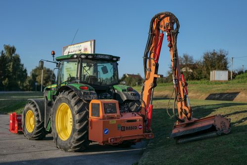 Free Tractor with mower attachment maintaining grass in rural Garešnica, Croatia under clear skies. Stock Photo