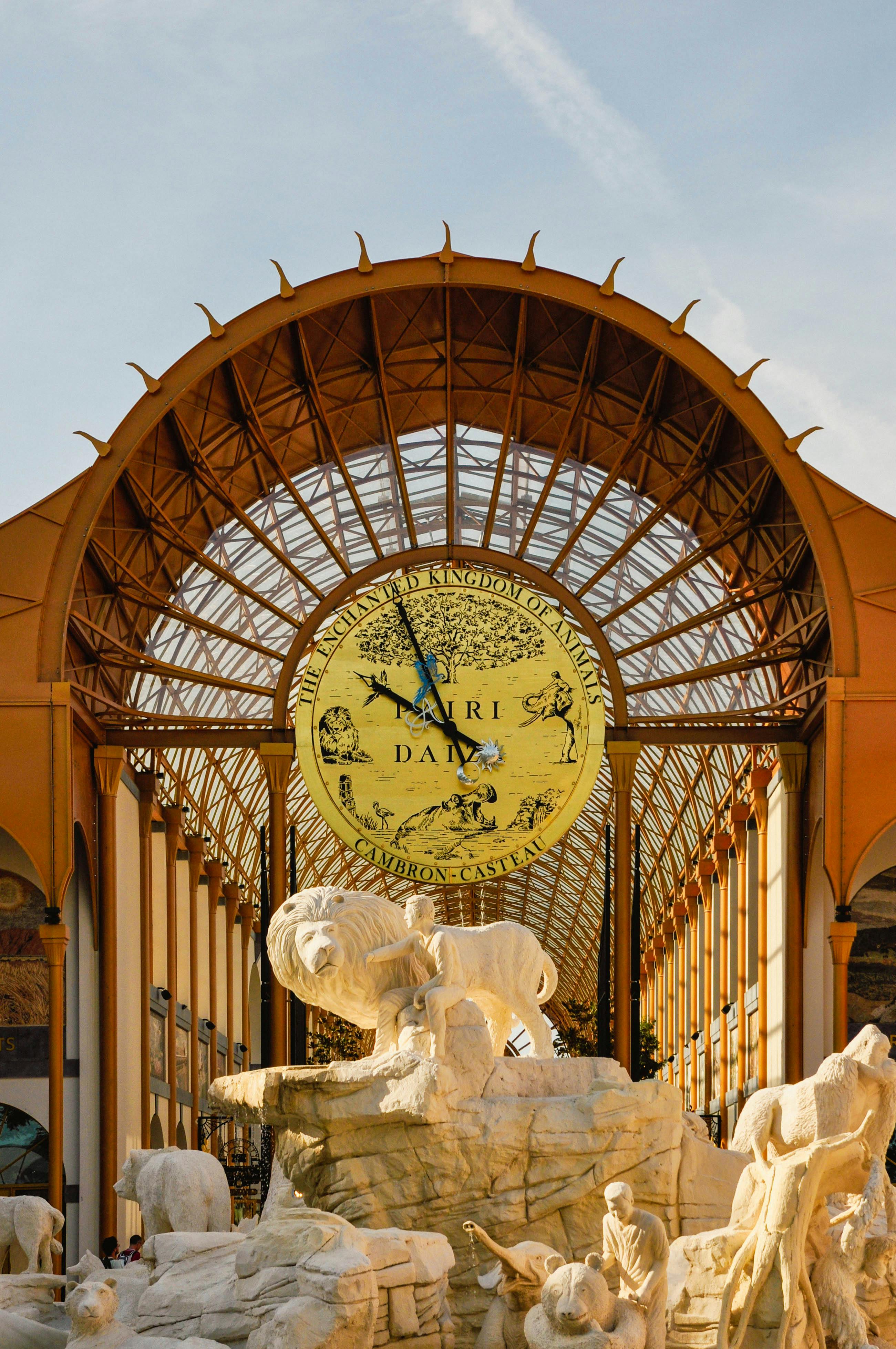 Stunning architectural entrance at Pairi Daiza Zoo featuring stone sculptures and a grand clock.