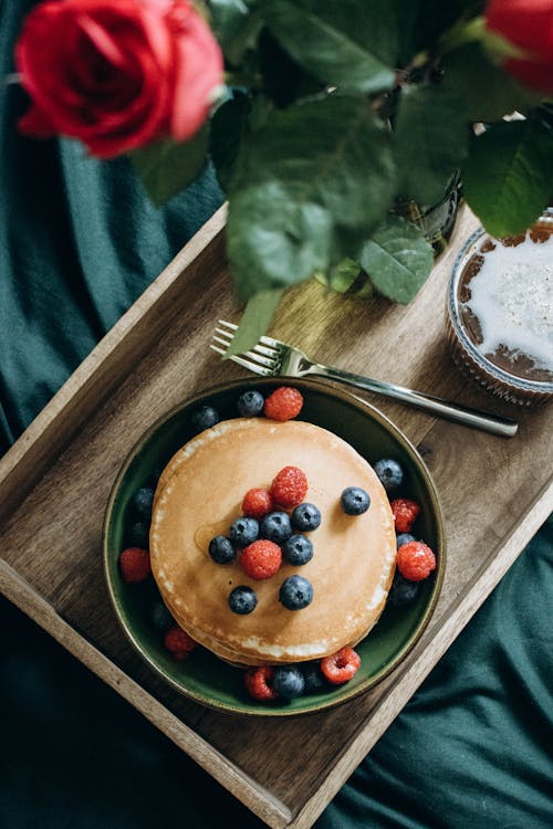 Free Pancakes with Berries and a Bunch of Flowers on a Tray Served to Bed  Stock Photo