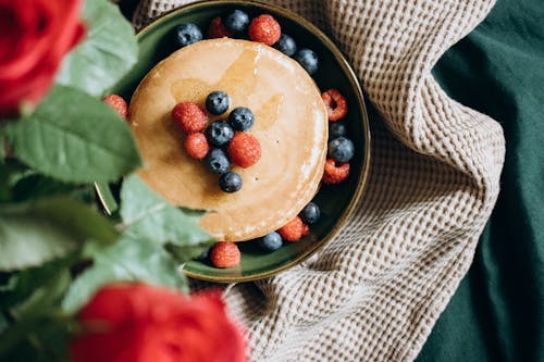 Free Pancakes with Berries and a Bunch of Flowers Served to Bed  Stock Photo