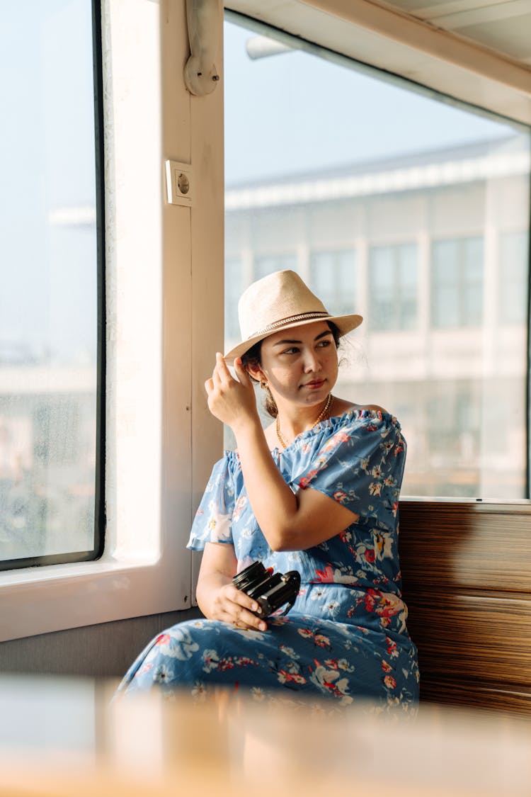 Woman In A Dress And Hat Sitting In A Ferry 