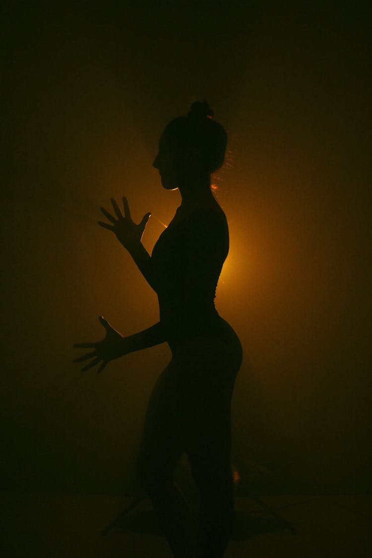 Silhouette Of Woman Dancing In Dark