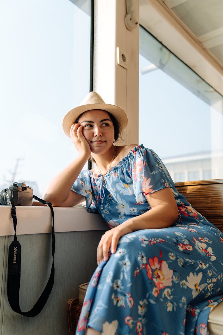 Woman In A Dress And Hat Sitting In A Ferry