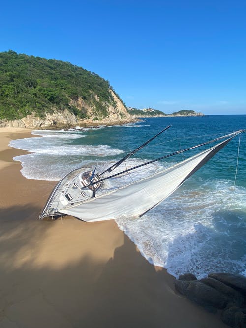 Small Sail Boat Stranded on a Sand Beach