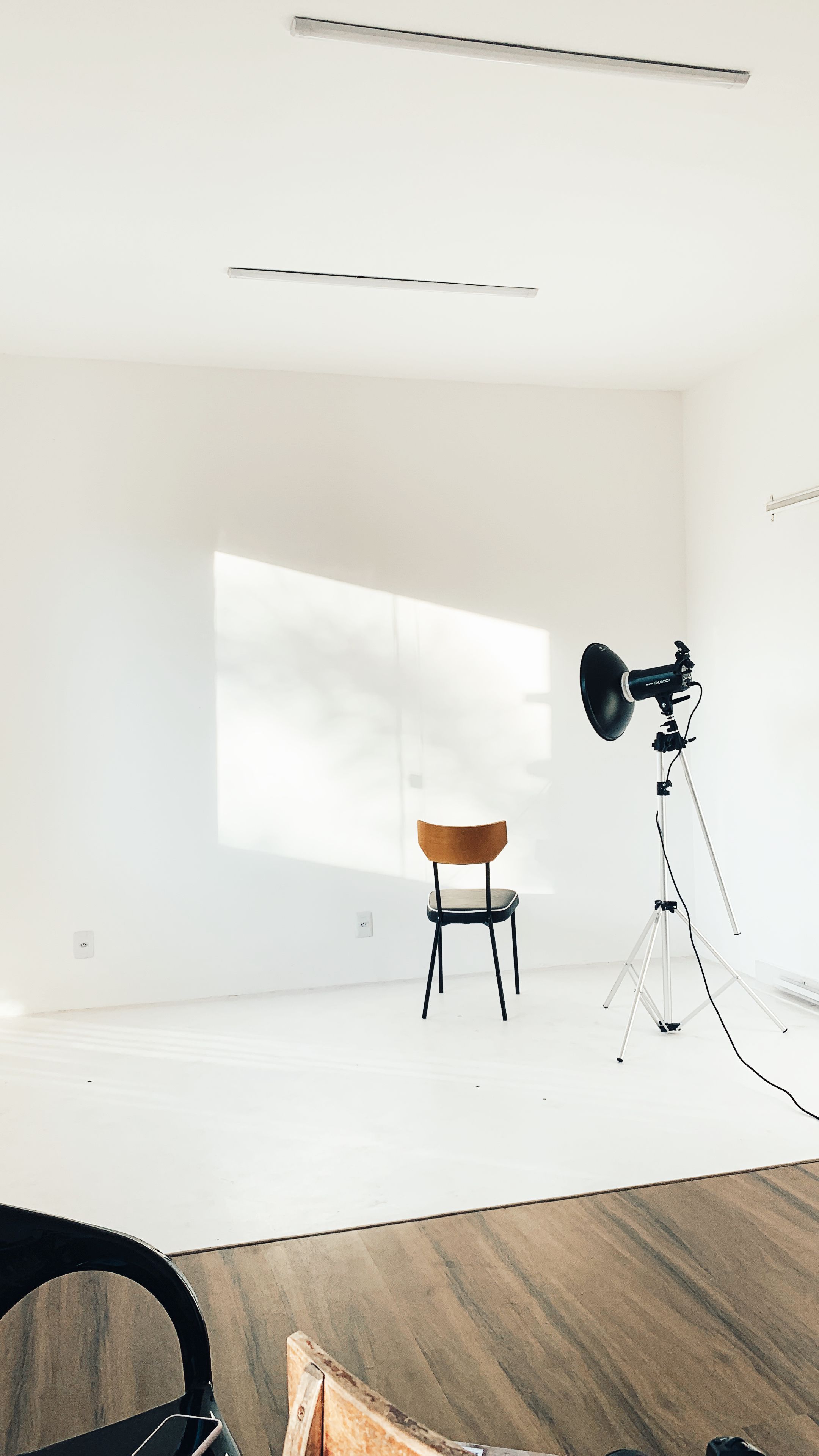 A minimalist studio setup with a chair and professional lighting equipment.
